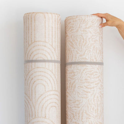 Two rolled play mats displaying the Arch and River Bend patterns, secured with grey straps